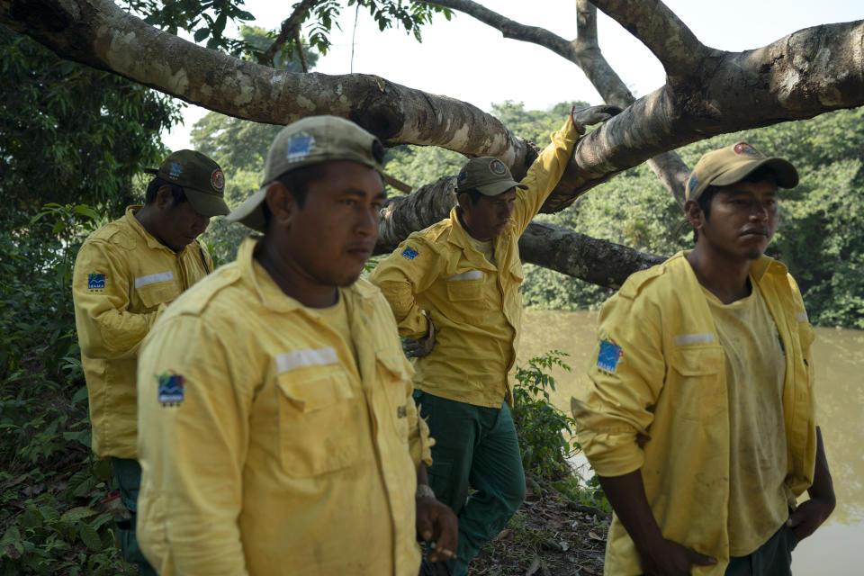 In this Aug. 27, 2019 photo, Kayapo indigenous members of PREVFOGO, a group that combats and helps to prevent fires, pause after working on the Bau indigenous reserve in Altamira in Brazil's Amazon where fires are burning. The group, which also works to improve the use of land for farming, depends on IBAMA, the Brazilian Institute of the Environment and Renewable Natural Resources, a government environmental agency. (AP Photo/Leo Correa)