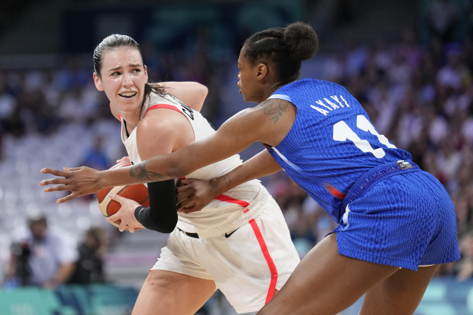 Bridget Carleton, of Canada, looks to get past Valeriane Ayayi, of France, in a women's basketball game at the 2024 Summer Olympics, Monday, July 29, 2024, in Villeneuve-d'Ascq, France. (AP Photo/Mark J. Terrill)