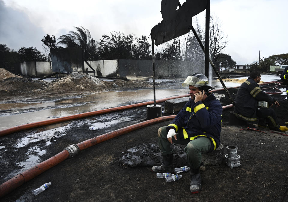 Firefighters rest at the site of a deadly fire at a large oil storage facility in Matanzas, Cuba, Tuesday, Aug. 9, 2022. The fire was triggered when lighting struck one of the facility's eight tanks late Friday, Aug. 5th. (Yamil Lage, Pool photo via AP)