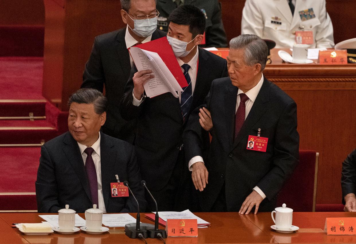 Chinese President Xi Jinping, left, looks away as former President Hu Jintao, right, speaks to him as he is removed from the closing session of the 20th National Congress of the Communist Party of China in October 2022. Rumors have spread that the party is operating "sleeper cells" of undercover agents in the U.S., but PolitiFact did not find evidence to back up those claims.