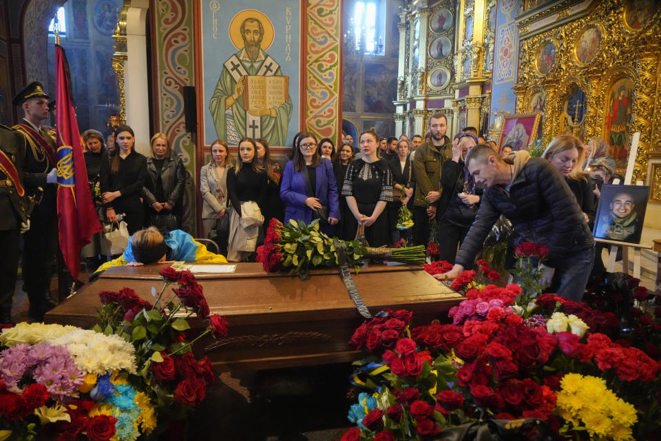 People pay their last tribute to volunteer soldier Oleksandr Makhov, 36, a well-known Ukrainian journalist, killed by Russian troops, during his funeral at St Michael cathedral in Kyiv, Ukraine, Monday, May 9, 2022. (AP Photo/Efrem Lukatsky)