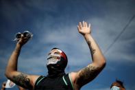 A protester wearing a face mask is seen rising his hands outside the Minneapolis Police third precinct, in Minneapolis