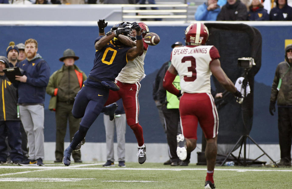 Oklahoma defensive back Woodi Washington, behind, breaks up a pass intended for West Virginia wide receiver Bryce Ford-Wheaton (0) during the second half of an NCAA college football game in Morgantown, W.Va., Saturday, Nov. 12, 2022. (AP Photo/Kathleen Batten)