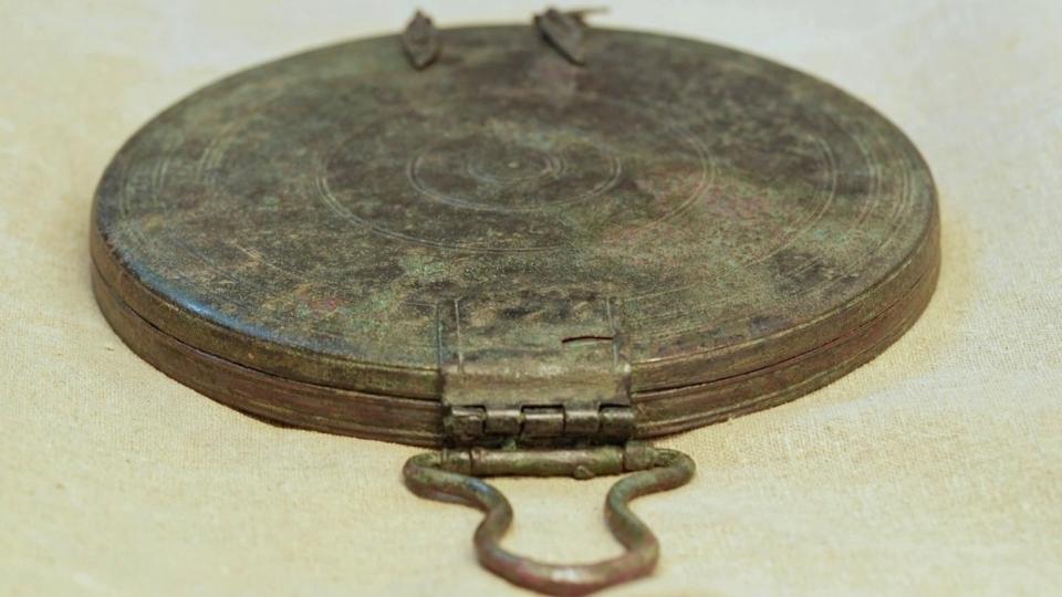 A picture of the bronze mirror showing its details and clasp.