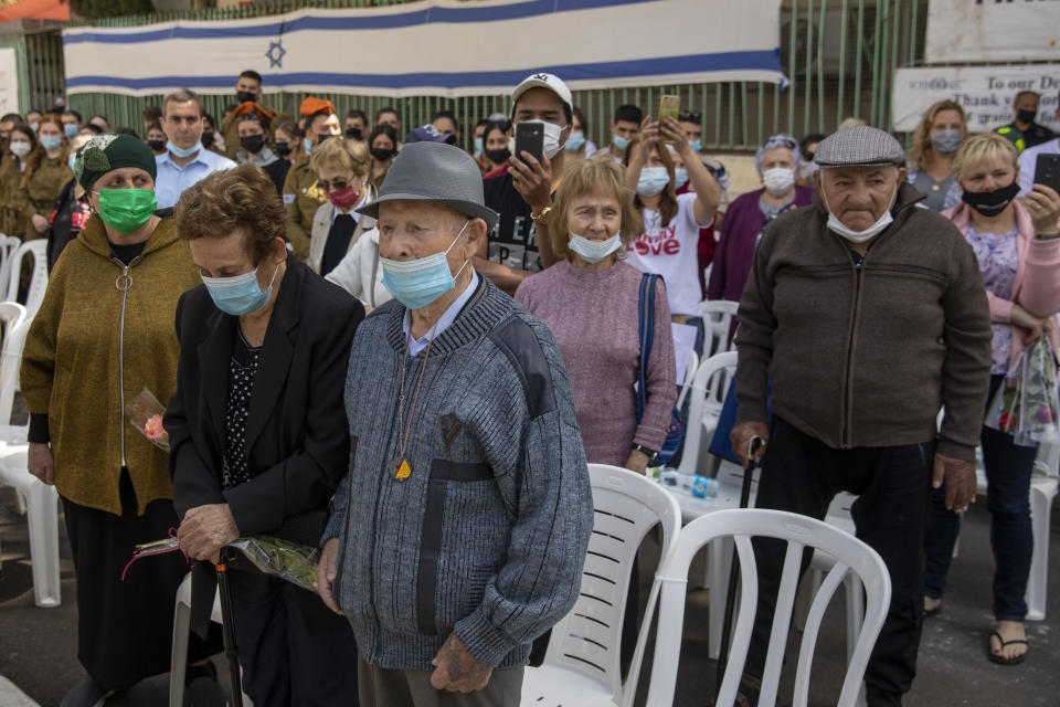 Holocaust survivors wearing face masks amid the coronavirus attend the yearly Holocaust Remembrance Day ceremony in Haifa, Israel, Thursday, April 8, 2021. (AP Photo/Ariel Schalit)