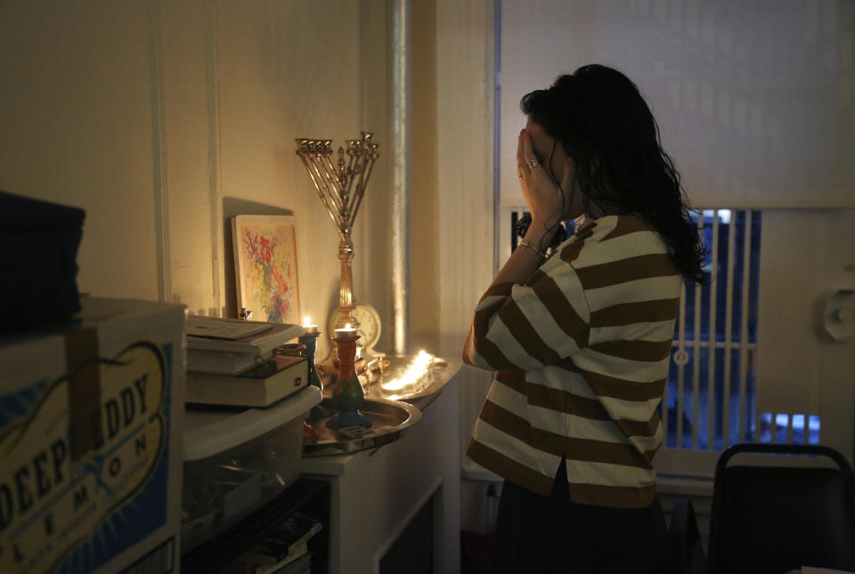 In this Friday, Jan. 3, 2020, photo, Chana Blum, 14, recites a blessing after lighting candles for Shabbat dinner in her family's home in New York. Two days later, Blum joined her older sister at the "No Hate, No Fear" solidarity march organized by New York's Jewish community in response to the recent string in anti-Semitic attacks. (AP Photo/Jessie Wardarski)