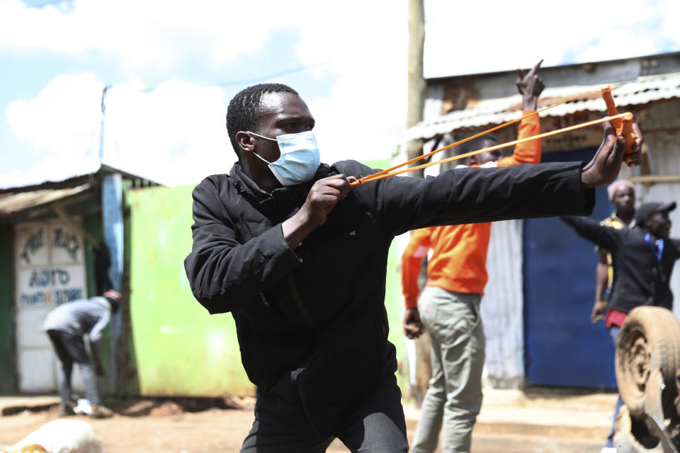 Protesters throw stones towards police officers during a mass rally called by the opposition leader Raila Odinga over the high cost of living in Kibera Slums, Nairobi, Kenya, Monday, March 27, 2023. Police in Kenya are on high alert ahead of the second round of anti-government protests organized by the opposition that has been termed as illegal by the government. Police chief Japheth Koome insists that Monday's protests are illegal but the opposition leader Raila Odinga says Kenyans have a right to demonstrate.(AP Photo/Brian Inganga)