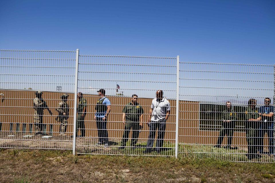 Border Patrol agents watch as demonstrators picket against the possible arrivals of undocumented migrants who may be processed at the Murrieta Border Patrol Station in Murrieta, California July 1, 2014. (REUTERS/Sam Hodgson)