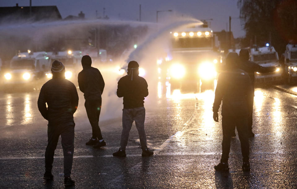 Police use a water cannon at Nationalist youths as they block a road near the Peace Wall in West Belfast, Northern Ireland, Thursday, April 8, 2021. Authorities in Northern Ireland sought to restore calm Thursday after Protestant and Catholic youths in Belfast hurled bricks, fireworks and gasoline bombs at police and each other. It was the worst mayhem in a week of street violence in the region, where Britain's exit from the European Union has unsettled an uneasy political balance. (AP Photo/Peter Morrison)