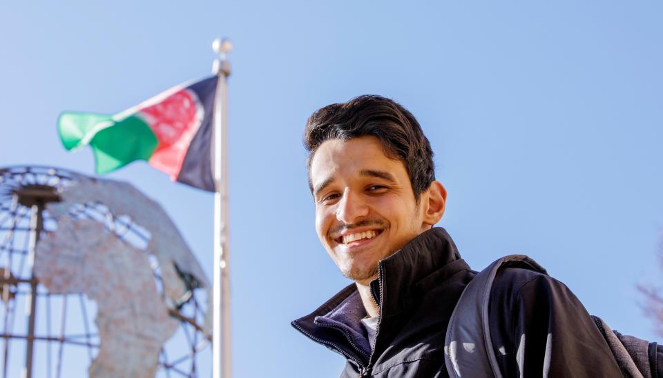 Tayyab Ghazniwal, an Afghan refugee attending Oklahoma State University in Stillwater, stands outside OSU's School of Global Studies and Partnerships where Afghanistan's flag is among several flags being flown.