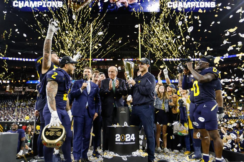 Michigan head coach Jim Harbaugh lifts the trophy to celebrate the 34-13 win over Washington to win the national championship game at NRG Stadium in Houston on Monday, Jan. 8, 2024.