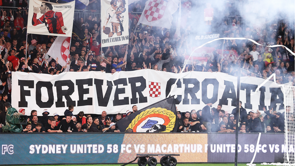 The crowd holding up a banner during the Australia Cup match.