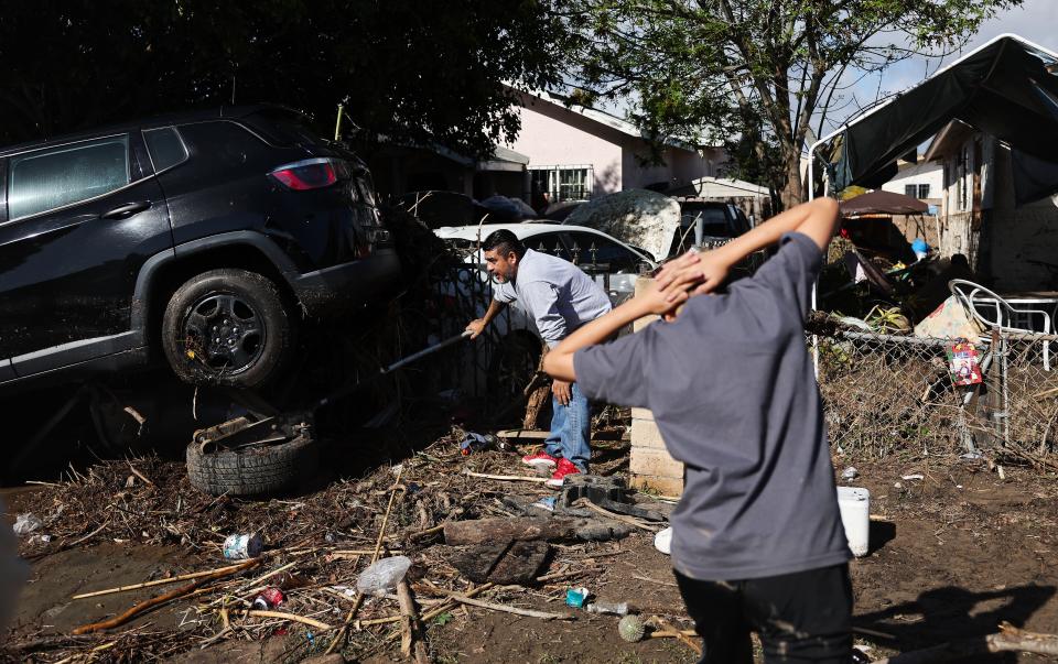 SAN DIEGO, CALIFORNIA - JANUARY 23: A person works to help tow away a vehicle dislodged by flooding the day after an explosive rainstorm caused flooding in areas of San Diego County on January 23, 2024 in San Diego, California. The intense rains forced dozens of rescues while flooding roadways and homes and knocking out electricity for thousands of residents.