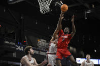 Stony Brook forward Chris Maidoh (4) shoots the ball while being defended by Charleston forward James Scott during the first half of an NCAA college basketball game in the championship of the Coastal Athletic Association conference tournament, Tuesday, March 12, 2024, in Washington. (AP Photo/Terrance Williams)