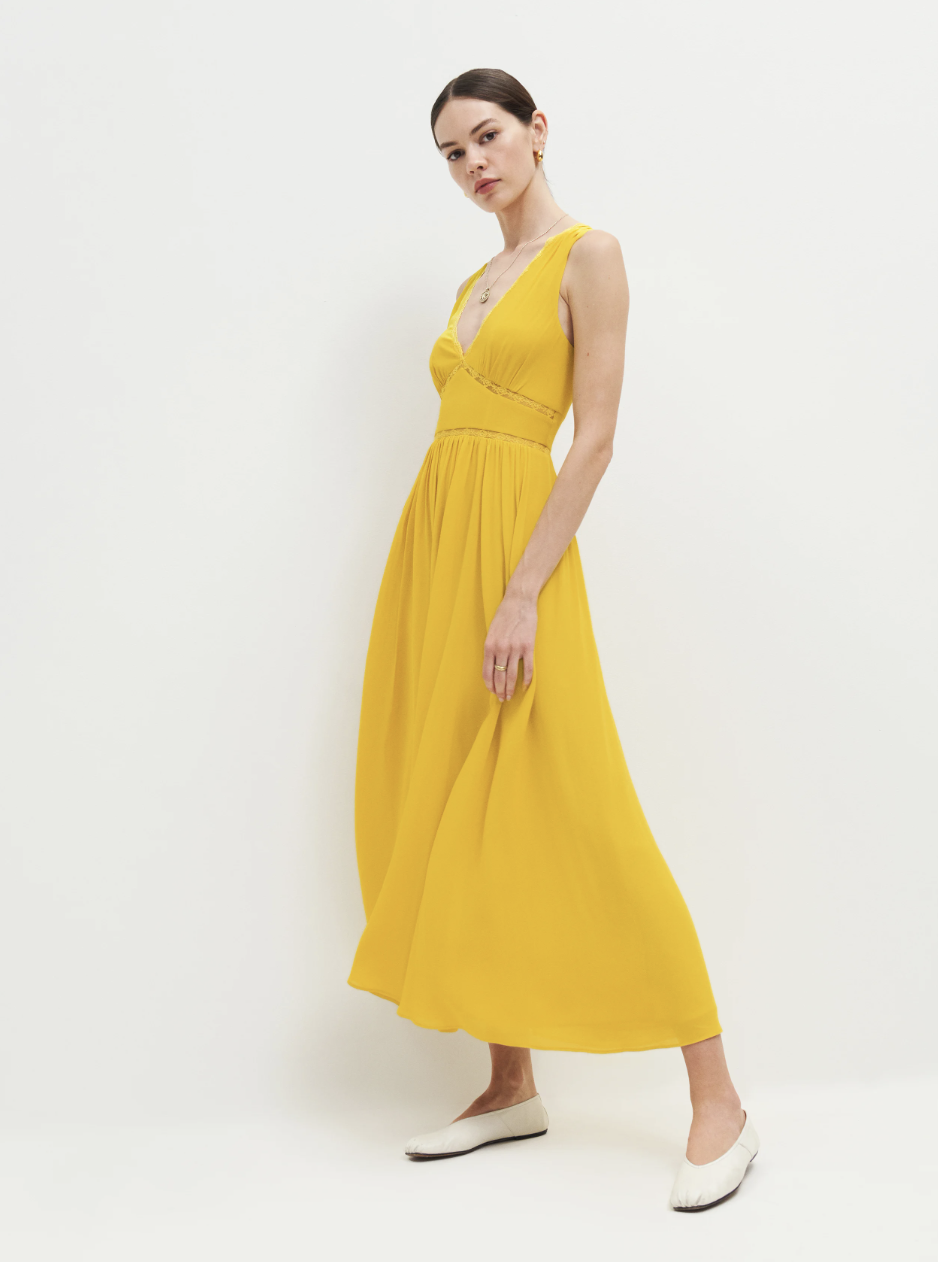 brunette model wearing white ballet flats and yellow midi Zaid Dress (Photo via Reformation)