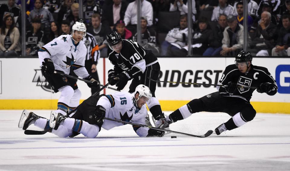 San Jose Sharks left wing James Sheppard, lower left, battles for the puck with Los Angeles Kings right wing Dustin Brown, right, as defenseman Brad Stuart, upper left, and left wing Tanner Pearson look on during the first period in Game 3 of an NHL hockey first-round playoff series, Tuesday, April 22, 2014, in Los Angeles. (AP Photo/Mark J. Terrill)