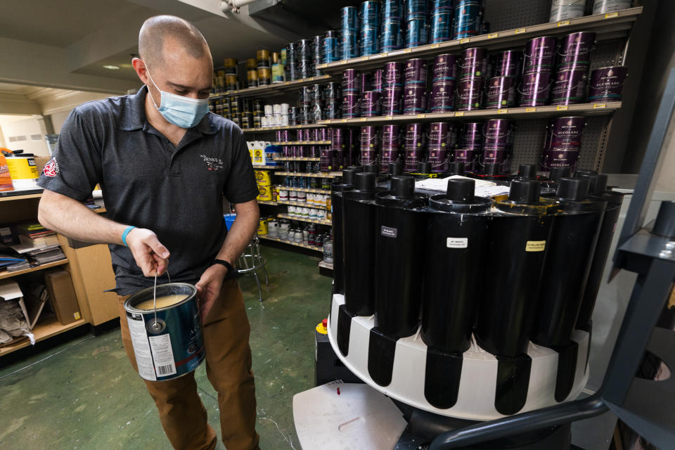 Billy Wommack, purchasing director at the W.S. Jenks & Sons hardware, carries a gallon of paint to a colorant dispenser at the mixing station of the hardware store's paint department, Friday, Sept. 24, 2021, in northeast Washington. (AP Photo/Manuel Balce Ceneta)