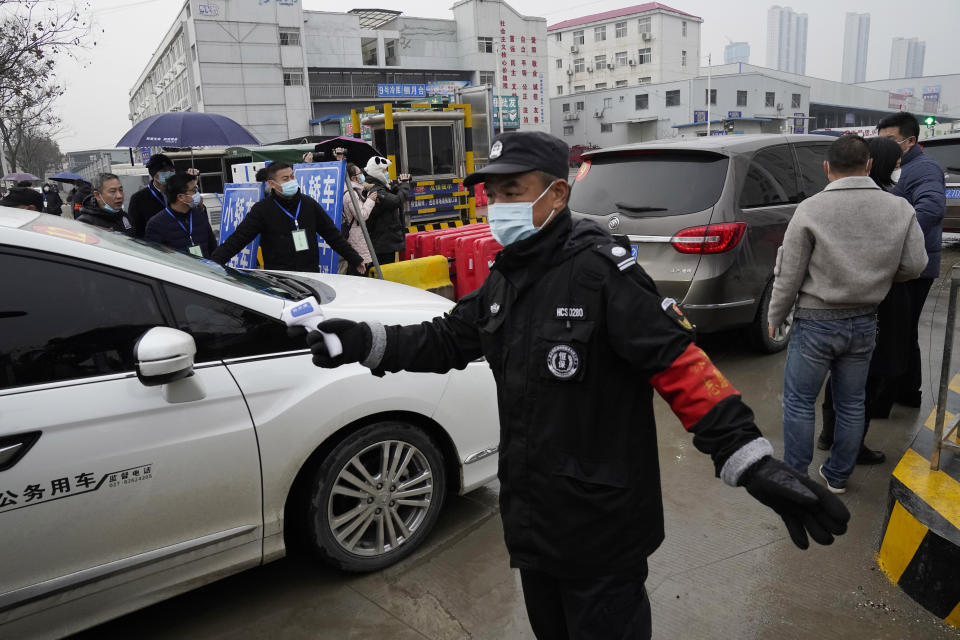 A security guard prevents journalists from following the World Health Organization team as they arrive at the Baishazhou wholesale market on the third day of field visit in Wuhan in central China's Hubei province on Sunday, Jan. 31, 2021. (AP Photo/Ng Han Guan)