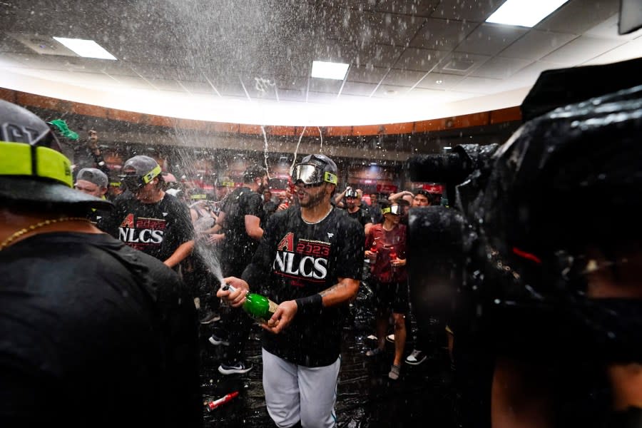 Members of the Arizona Diamondbacks celebrate after the Diamondbacks defeated the Los Angeles Dodgers 4-2 in Game 3 to win a baseball NL Division Series, Wednesday, Oct. 11, 2023, in Phoenix. (AP Photo/Ross D. Franklin)