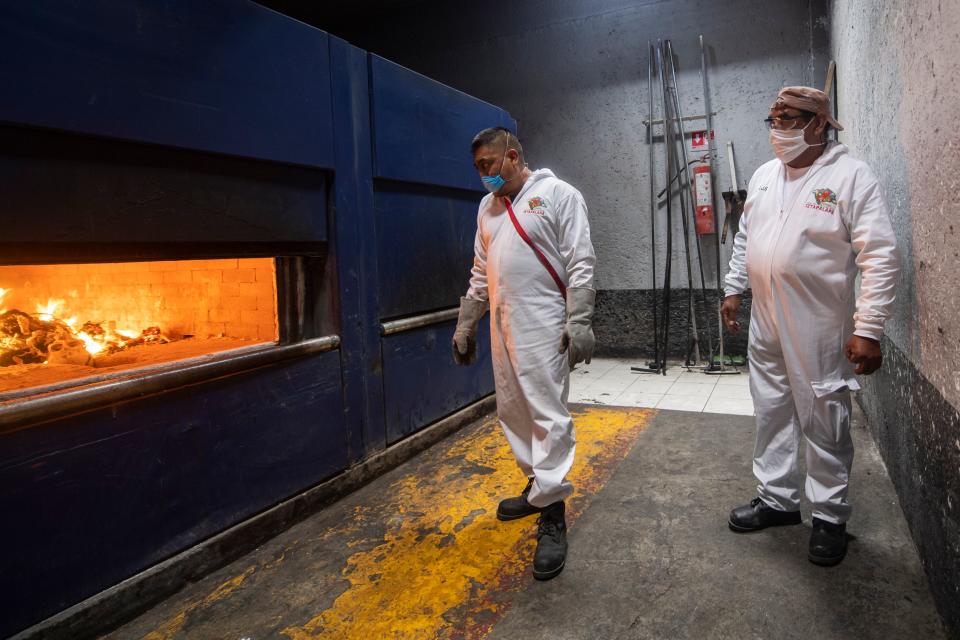 Los empleados del crematorio de Iztapalapa observan cómo un cuerpo es incinerado en el horno, mientras que la pandemia por coronavirus golpea a México y ya ha dejado miles de muertos.(Photo by PEDRO PARDO/AFP via Getty Images)