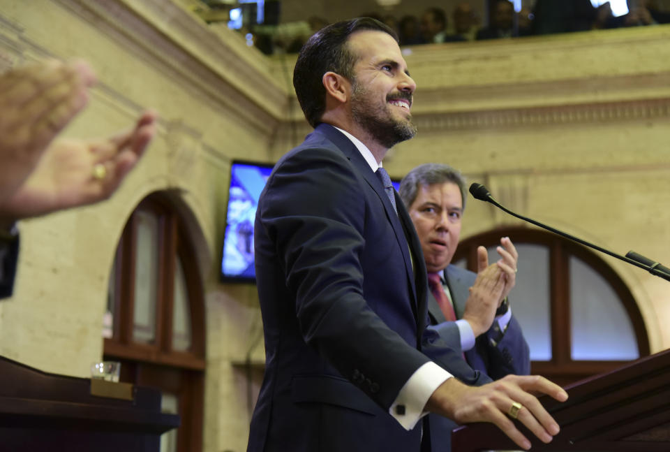 Lawmakers applaud as Puerto Rico's Gov. Ricardo Rossello arrives to deliver his commonwealth address at the seaside Capitol in San Juan, Puerto Rico, Wednesday, April 24, 2019. He pledged on Wednesday to lift the U.S. territory from a deep recession by creating more jobs, reversing a migration exodus and implementing a range of incentives as the island struggles to recover from Hurricane Maria. (AP Photo/Carlos Giusti)