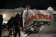 Protesters hold a banner which reads in Greek "confrontation" as they protest the shooting in the head of a 16-year-old youth, outside the Greek parliament , in central Athens Monday Dec 5, 2022. A police officer has been arrested in northern Greece after a 16-year-old boy was shot in the head and seriously injured during a car chase after he allegedly failed to pay the bill at a gas station(AP Photo/Michael Varaklas)