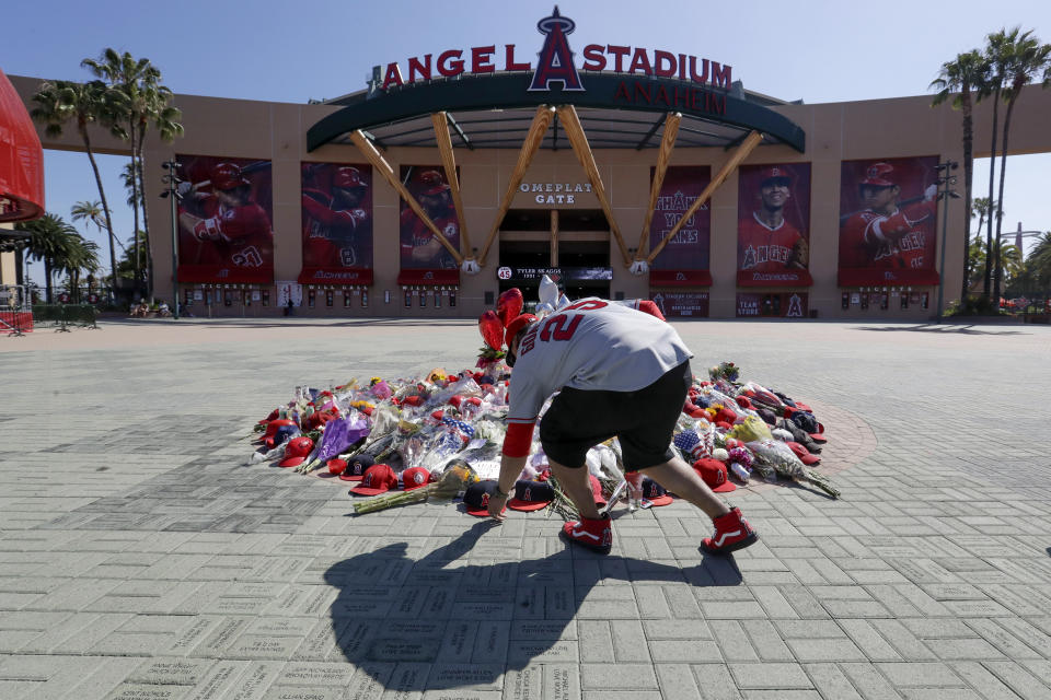 Miguel Gonzalez places a hat on a memorial for Los Angeles Angels pitcher Tyler Skaggs at Angel Stadium in Anaheim, Calif., Tuesday, July 2, 2019. The 27-year-old left-hander died in his Texas hotel room, where he was found unresponsive Monday afternoon. (AP Photo/Chris Carlson)