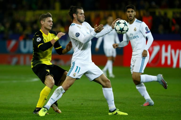 Real Madrid's forward Gareth Bale (C) and Dortmund's defender Lukasz Piszczek vie for the ball during the UEFA Champions League Group H football match September 26, 2017