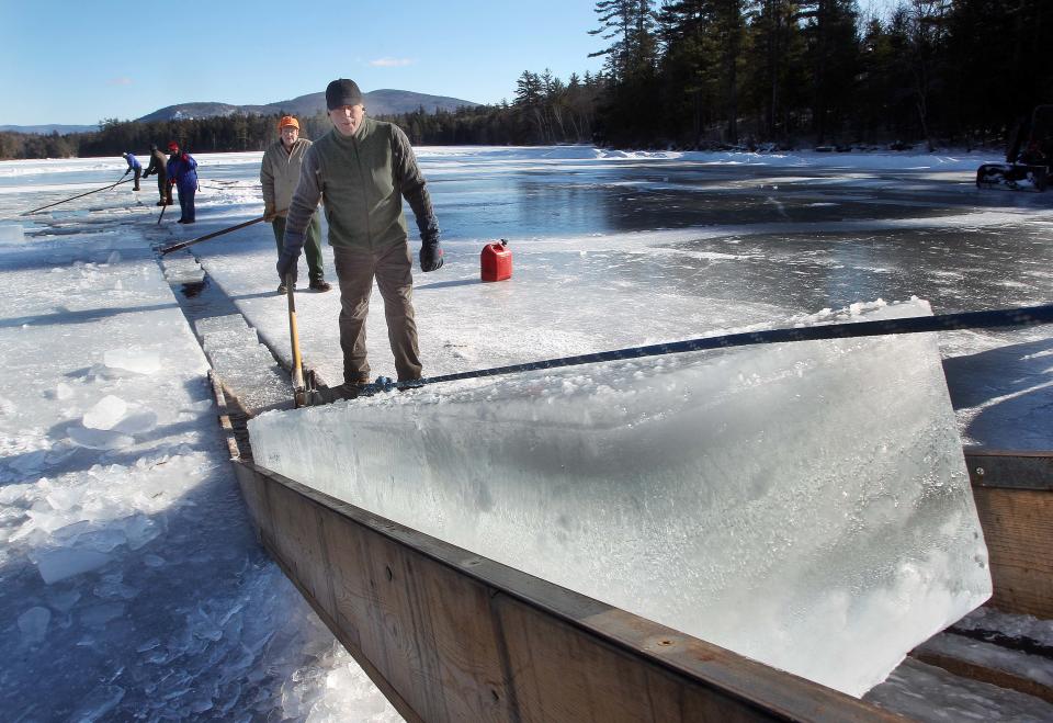 John Jurczynski guides blocks of ice from a trough on Squaw Cave on Squam Lake during the annual ice harvest Thursday Jan. 9, 2014 in Sandwich, N.H. For mare than a century ice has been harvested on the lake and used for summer residents at the Rockywold-Deephaven Camp (AP Photo/Jim Cole)