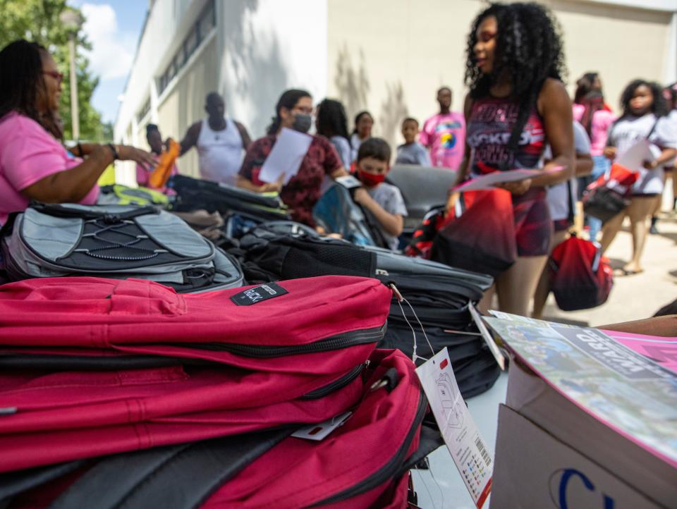 Backpacks fill tables to be given away to students during the People Against Violence Enterprises (PAVE) Stop The Youth Violence rally, Saturday, July 30, 2022 at Santa Fe Community College in Gainesville, Florida.