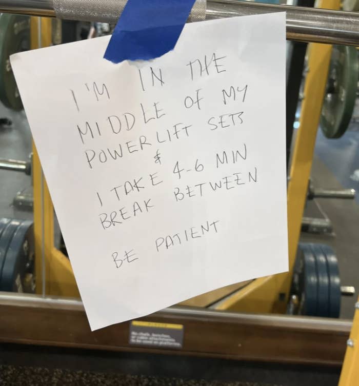 Note taped to gym equipment reads, “I’m in the middle of my powerlift sets & I take 4-6 min break between. Be patient.”