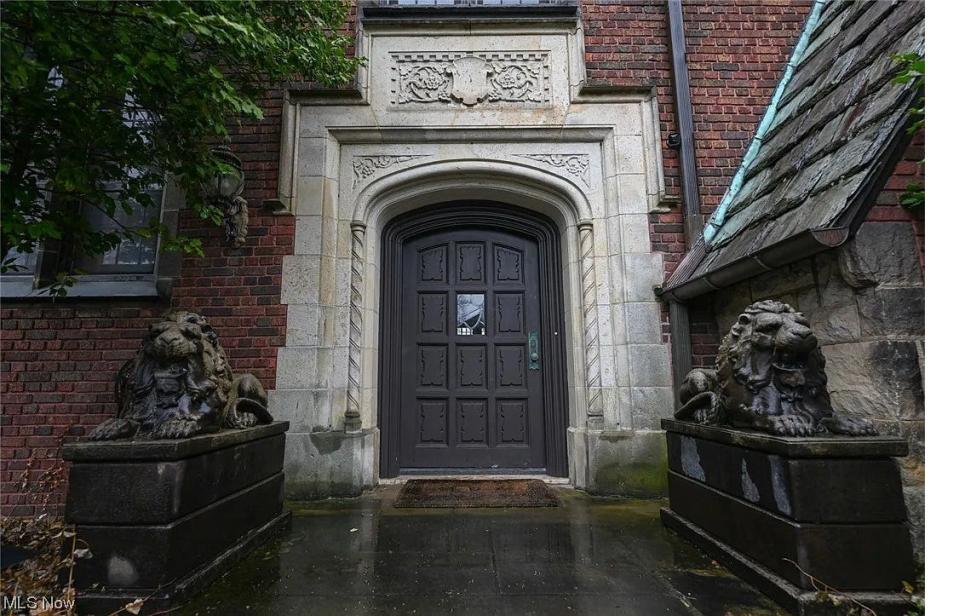 A pair of lions stand guard outside the door of an historic home for sale in Akron.