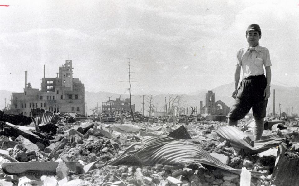 A man stand on the debris after the atomic bomb completely destroyed the city in August 1945 in Hiroshima - Getty Images Contributor