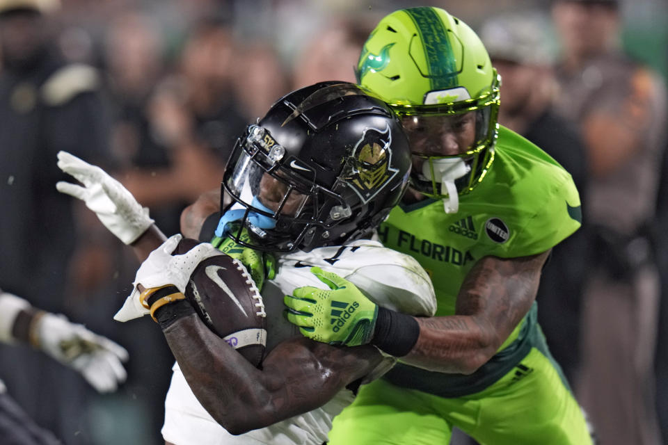 UCF wide receiver Ryan O'Keefe (4) is stopped by South Florida safety Will Jones II after a catch during the first half of an NCAA college football game Saturday, Nov. 26, 2022, in Tampa, Fla. (AP Photo/Chris O'Meara)