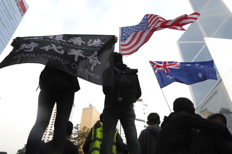 Participants wave a U.S. flag and a colonial flag during a rally demanding electoral democracy and call for boycott of the Chinese Communist Party and all businesses seen to support it in Hong Kong, Sunday, Jan. 19, 2020. Hong Kong has been wracked by often violent anti-government protests since June, although they have diminished considerably in scale following a landslide win by opposition candidates in races for district councilors late last year. (AP Photo/Ng Han Guan)