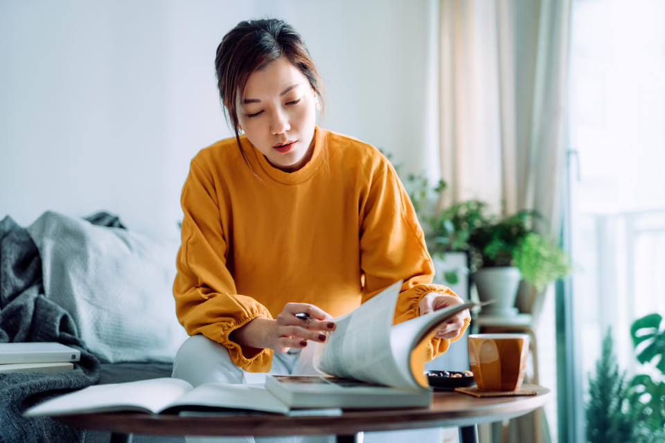 A woman doing schoolwork at her coffee table