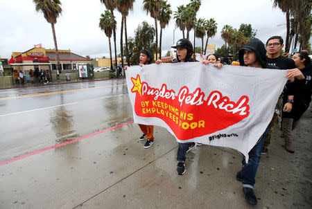 Local fast food workers take part in nationwide protests to denounce President-elect Donald Trump's nomination of Andy Puzder, a restaurant mogul who owns Carl's Jr. and other chains, as U.S. Secretary of Labor outside a Carl's Jr. restaurant in Los Angeles, California, U.S., January 12, 2017. REUTERS/Mike Blake