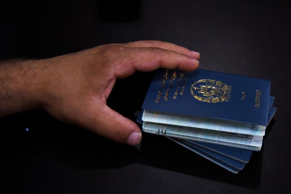 An Afghan man holds his family’s passports. The visa lottery program offers a pathway to the US with minimum eligibility requirements.