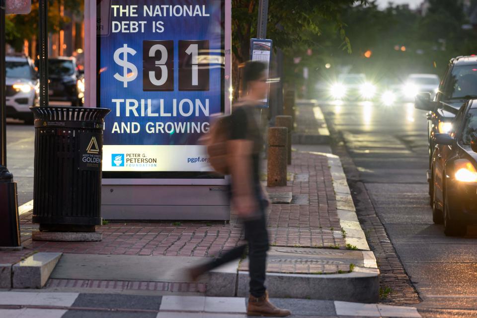 A poster at a bus shelter shows the national debt in Washington, DC, on May 21, 2023. Florida Republicans disagree on whether the deal to avoid a catastrophic default goes far enough in cutting spending.