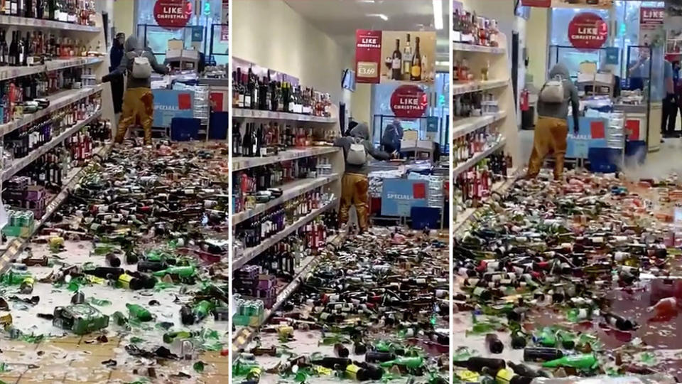 A woman smashes bottles of alcohol at the Aldi.