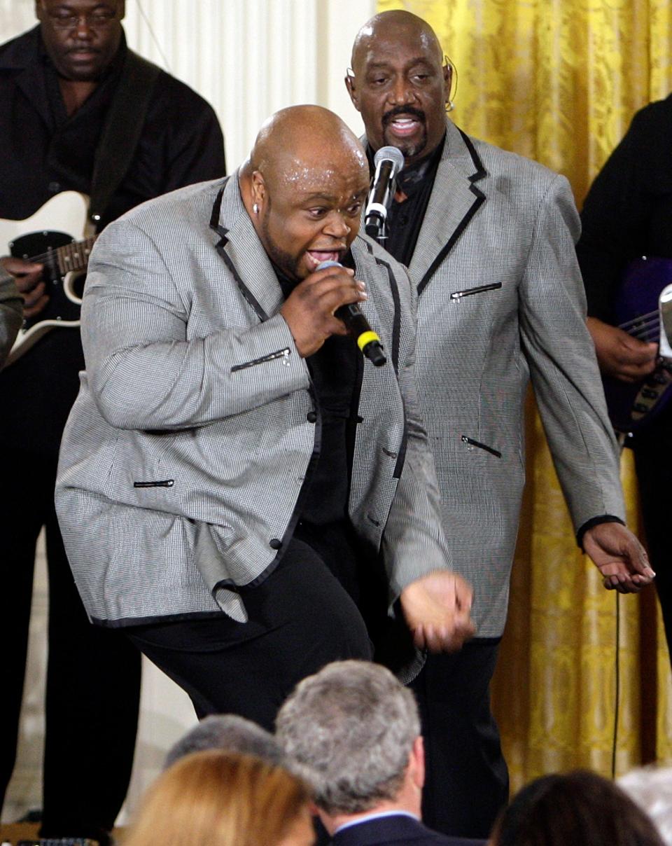 Bruce Williamson, center, and Otis Williams, right, of The Temptations perform for President George W. Bush, seated, center back to camera, at a celebration of African American History Month, Tuesday, Feb. 12, 2008, in the East Room of the White House in Washington.