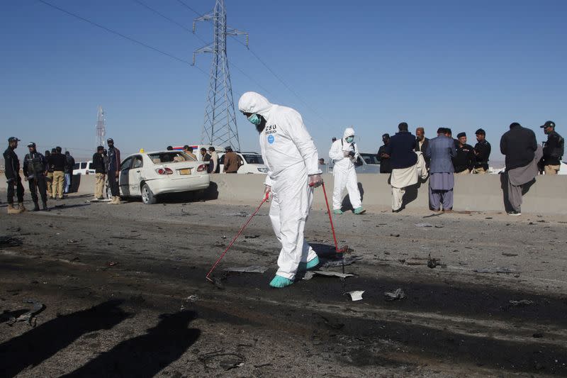 A member of a crime scene unit surveys the site after a suicide bomb blast on a police patrol in Quetta