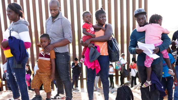 Immigrants from Haiti, who crossed through a gap in the U.S.-Mexico border barrier, wait in line to be processed by the U.S. Border Patrol in Yuma, Arizona. (Photo: Mario Tama/Getty Images)