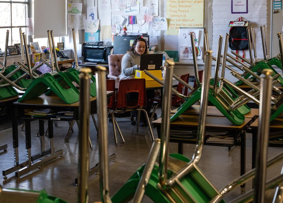 A teacher interacts with students virtually while sitting in an empty classroom at Hazelwood Elementary School in Louisville, Kentucky, early last year. Jefferson County Public Schools, and many others, switched to remote teaching last winter in response to severe staffing shortages caused by the omicron variant of COVID-19.