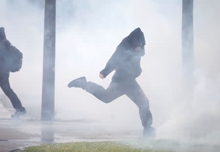 A protester reacts to tear gas canisters fired by police at a demonstration during the Act XXIV (the 24th consecutive national protest on Saturday) of the yellow vests movement in Strasbourg, France, April 27, 2019. REUTERS/Vincent Kessler