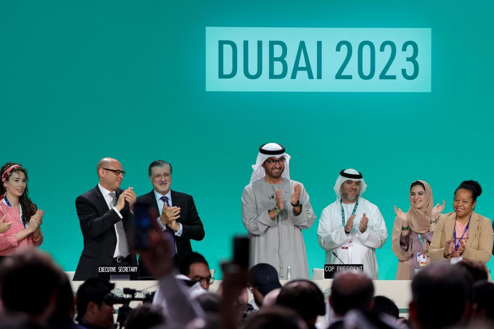 COP28 president Sultan Ahmed Al Jaber (C) applauds among other officials (AFP via Getty Images)
