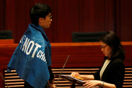 Newly-elected lawmaker Baggio Leung wears a banner "Hong Kong is not China" while taking oath at the Legislative Council. REUTERS/Bobby Yip