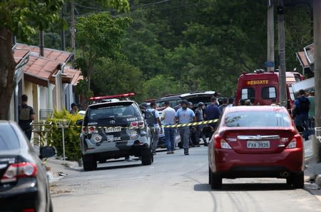 A police vehicle and an ambulance are seen near a site where an armed gang holds people hostage after they robbed a securities company at the Viracopos airpoart freight terminal, in Campinas