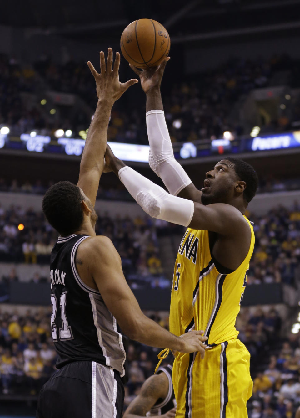 Indiana Pacers center Roy Hibbert, right, shoots over San Antonio Spurs forward Tim Duncan in the first half of an NBA basketball game in Indianapolis, Monday, March 31, 2014. (AP Photo/Michael Conroy)