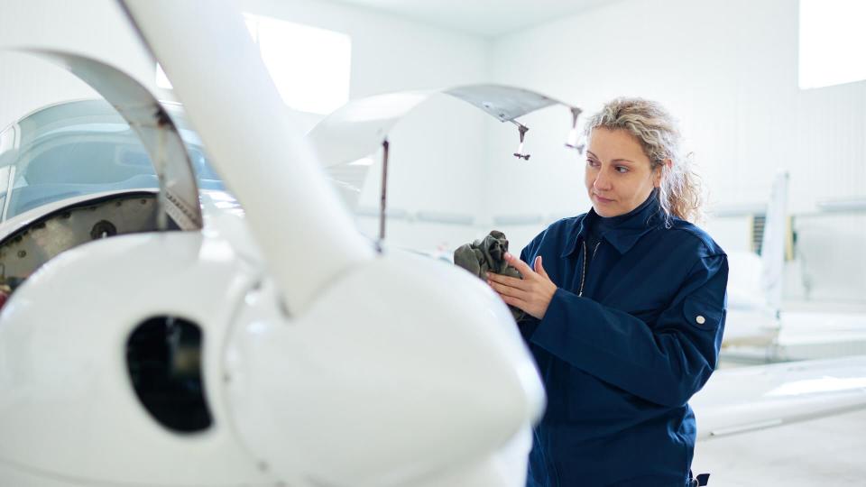 Female mechanic wiping hands after repair.